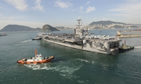 Tugboats pulling the USS George Washington out of the port of Busan, South Korea, October 2011.
