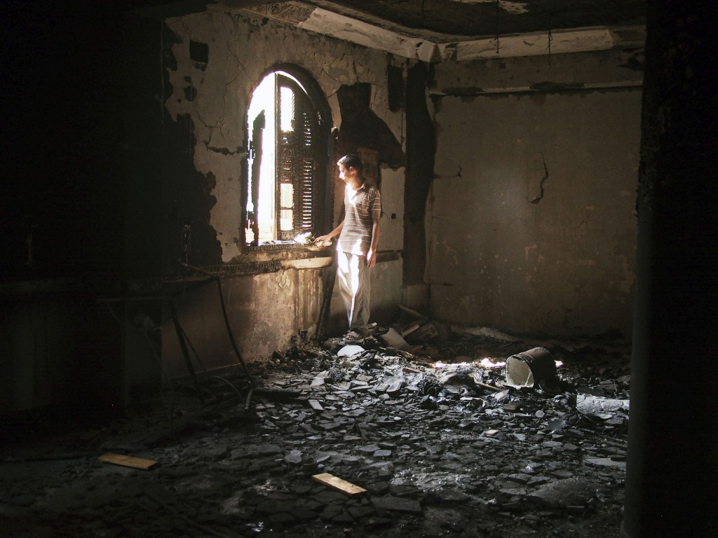 Egypt, August 2013. A local resident stands amid the charred remains of the Virgin Mary church in the village of Al Nazla, about 120 kilometres outside Cairo. The church was burned and looted by a mob of alleged pro-Muslim Brotherhood villagers. Photo by Moises Saman/MAGNUM