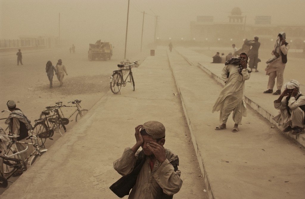 Afghanistan, March 2005. A boy covers his eyes during a sandstorm in the southern city of Kandahar.  Photo by Moises Saman/MAGNUM 