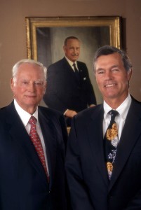 Barron and Steven M. Hilton with portrait of Conrad N. Hilton.