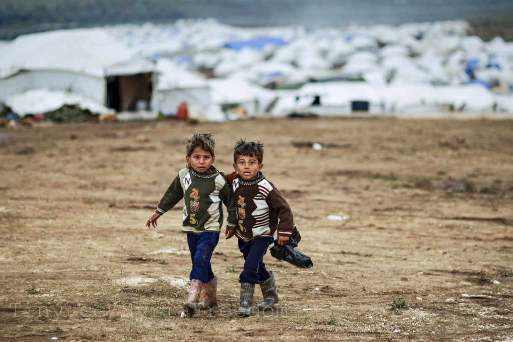 Syrian boys, whose family fled their home in Idlib, walk to their tent, at a camp for displaced Syrians, in the village of Atmeh, Syria. Credit FreedomHouse.