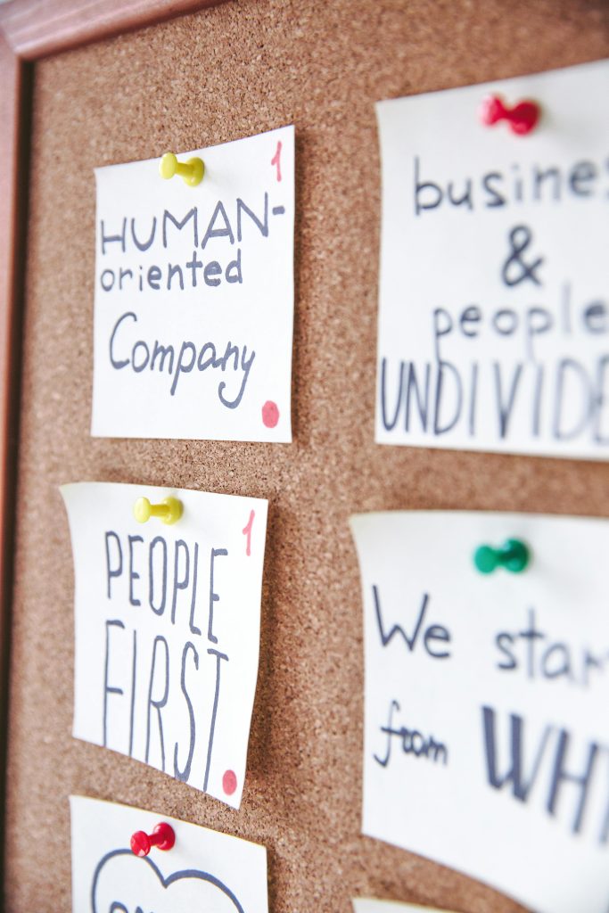 labels on cork board, one says 'human oriented company', another 'people first'